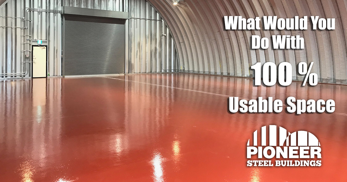 Interior of a large steel building with a red floor